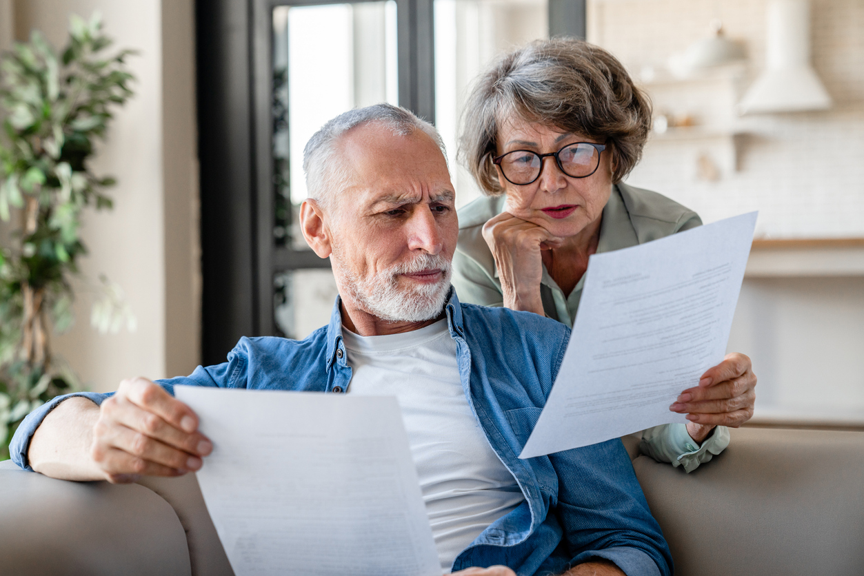 Senior grandparents reading documents, having issue problem debt with money loss deed of variation solicitors